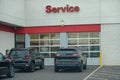 Black SUV cars waiting at the garage doors of a automobile service center to be let in for repair