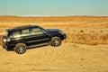 Black SUV and Giant gas crater in Turkmenistan `Gates of Hell`.