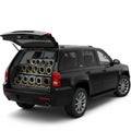 A black SUV with its rear hatch open reveals an array of cylindrical jet engines stacked Royalty Free Stock Photo