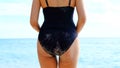 Black swimsuit wearer she walks on the beach and she`s going to swim in the sea Royalty Free Stock Photo