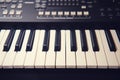 Black synthesizer with white keys, modern electronic piano with sliders and buttons for recording music Royalty Free Stock Photo