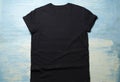 Black t shirt clothes on blue wooden table background