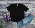 Black T Shirt mockup flat lay on purple brick background with pu