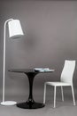 Black table, chair and the floor lamp on gray background. Modern furniture composition for interior.