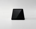 Black Tablet Computer Standing Upright on a White Surface with Dark Screen and Subtle Lighting device Royalty Free Stock Photo