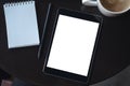 A black tablet pc with blank white desktop screen with notebook and coffee cup on the table Royalty Free Stock Photo