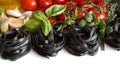 Black Tagliatelle pasta with cherry tomatoes, garlic and herbs Royalty Free Stock Photo