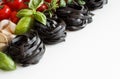 Black Tagliatelle pasta with cherry tomatoes, garlic and herbs Royalty Free Stock Photo