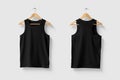 Black Tank Top Shirt mockup on wooden hanger isolated on light grey background front and rear side view. Royalty Free Stock Photo
