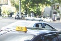 Black taxi cars with yellow standard signs on top parked or stoped on busy city street. Royalty Free Stock Photo