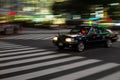 Black taxi rushing in the streest of Tokyo at night with motion