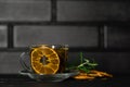 Black tea. Cup of tea with dried orange. Herbal tea with dried citrus. Black tea cup on wooden background
