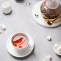 Black tea in a cup with a reflection of bird and a teapot with flowering branches. Poster, greeting card, menu. Spring tea party,