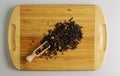 Black tea with dry citrus fruits, banana and flower petals. Wooden spatula with tea and a handful of tea mixture on a wooden board Royalty Free Stock Photo