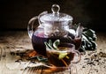 Black tea with fresh sage, glass cup and teapot, dark wood backg