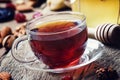 Black tea in a glass cup with honey, dried fruits and nuts, sweet, vintage wooden background, selective focus Royalty Free Stock Photo