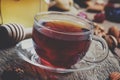 Black tea in a glass cup with honey, dried fruits and nuts, sweet, vintage wooden background, selective focus and toned image Royalty Free Stock Photo