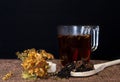 Black tea with herbs and sugar on a black background