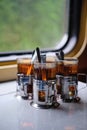 Black tea glasses in cup holders on a table on a train Royalty Free Stock Photo