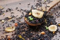 Black tea leaves in a wooden spoon. blended tea with flower petals and pieces of dried fruit on a wooden table. black blended tea Royalty Free Stock Photo