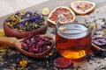 Black tea leaves in a wooden spoon. blended tea with flower petals and pieces of dried fruit on a wooden table. black blended tea Royalty Free Stock Photo