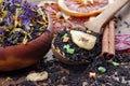 Black tea leaves in a wooden spoon. blended tea with flower petals and pieces of dried fruit on a wooden table. black blended tea Royalty Free Stock Photo