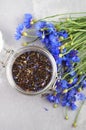 Black tea mix with dried cornflower petals and thyme in glass jar. Herbal tea