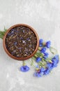 Black tea mix with dried cornflower petals and thyme in wooden bowl. Herbal tea
