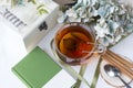 Black tea mug, green cover book, cinnamon sticks, box, teaspoon, hydrangea flowers