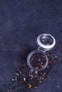 Black tea with natural additives in a glass jar on a dark background