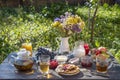 Tea, pancakes, milk and jam on the breakfast table in the autumn garden, close up Royalty Free Stock Photo