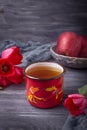Black tea, red apple and spring flowers tulips on a dark background. Rustic style, free space Royalty Free Stock Photo