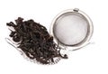 Black tea, and tea strainer with chain, isolated on a white background. Royalty Free Stock Photo