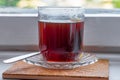 Black tea in a vintage glass on the windowsill