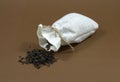 Black tea was spilling out of the tea bag. Brown background Royalty Free Stock Photo