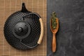 Black teapot with green tea on a dark background. Top view with copy space Royalty Free Stock Photo