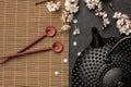 Black teapot with sakura branch and chopsticks on a dark background.Top view with copy space Royalty Free Stock Photo