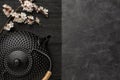 Black teapot with sakura branch on a dark background.Top view with copy space Royalty Free Stock Photo