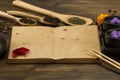 Black teapot, two cups, tea collection, flowers, old blank open book on wooden background. Royalty Free Stock Photo