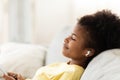 Black Teen Girl Listening Music Wearing Earbuds Relaxing At Home Royalty Free Stock Photo