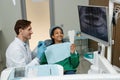 Black teenage girl at dental checkup in clinic looking in mirror and smiling Royalty Free Stock Photo