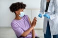 Black teen stopping medical worker from making covid vaccine shot, being afraid of coronavirus immunization at clinic Royalty Free Stock Photo