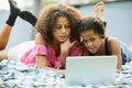 Black teenagers browsing internet on laptop