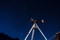 Black telescope reflector on a tripod under the starry dark blue night sky Royalty Free Stock Photo