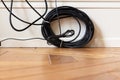 Black television cable on a wooden floor