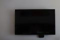 Black television screen on white wall
