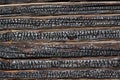 Black texture of burnt wood. The wall of the house is made of charred logs. A fragment of the wall of an old log house after a Royalty Free Stock Photo