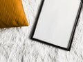 Black thin wooden frame with blank copyspace as poster photo print mockup, golden cushion pillow and fluffy white Royalty Free Stock Photo