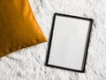 Black thin wooden frame with blank copyspace as poster photo print mockup, golden cushion pillow and fluffy white Royalty Free Stock Photo
