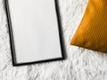 Black thin wooden frame with blank copyspace as poster photo print mockup, golden cushion pillow and fluffy white Royalty Free Stock Photo